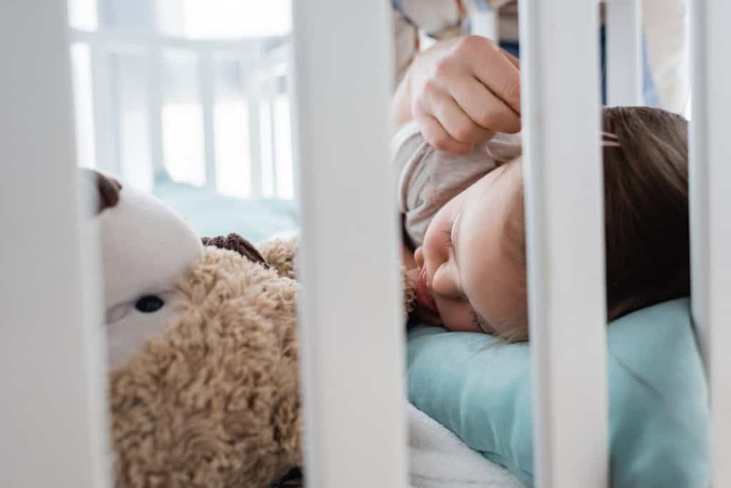 baby sleep consultant stroking sleeping baby's cheek