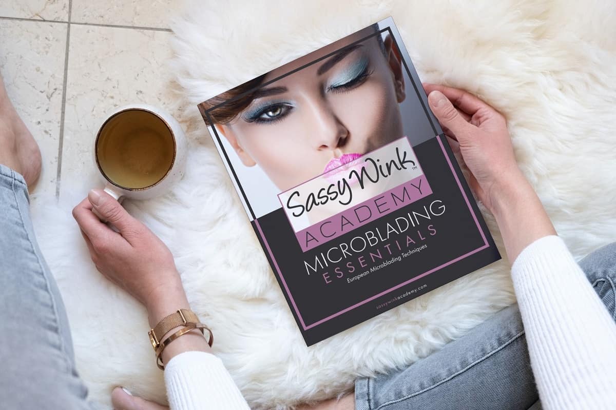 Woman holding Sassy Wink Academy Microblading Essentials Workbook