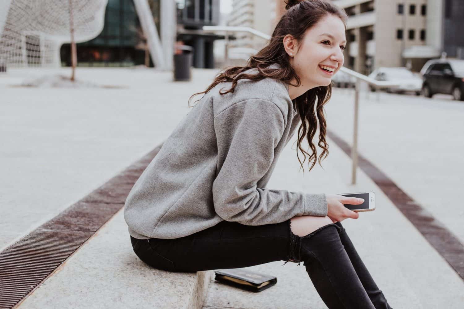 woman smiling holding smartphone